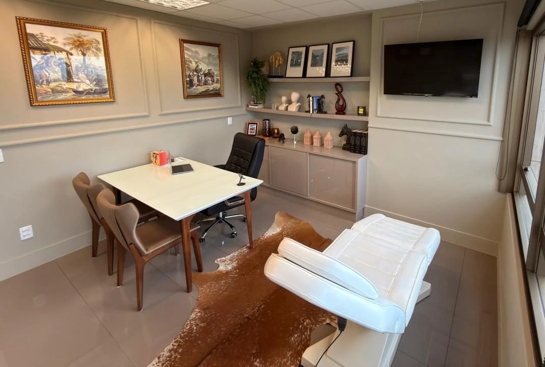 Consultório do Dr. Ícaro Queiroz em São José do Rio Preto, com a mesa de atendimento e a maca